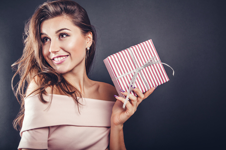 Man gives a gift box to his girlfriend for Valentines day on black background.の写真素材