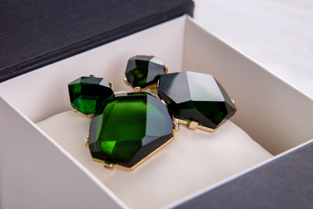 Gold earrings with emerald in the gift boxの写真素材