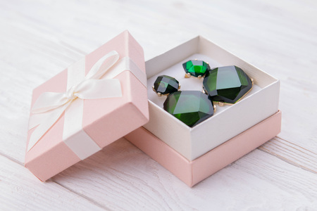 Gold earrings with emerald in the gift boxの写真素材