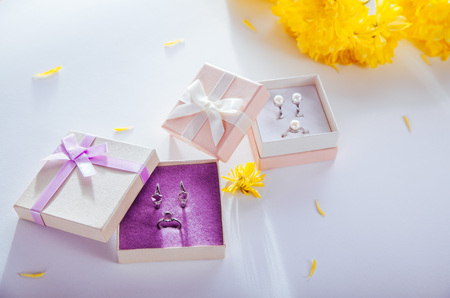 Set of pearl and amethyst jewellery in gift boxes with yellow flowersの写真素材