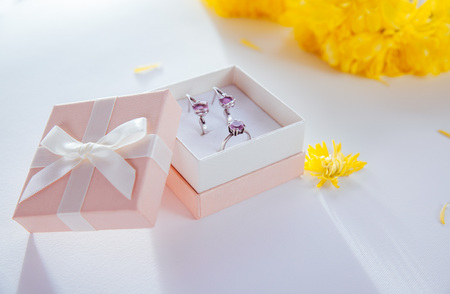 Silver ring and earrings with amethyst in the gift box on wooden backgroundの写真素材