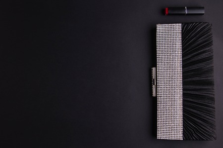 Female cocktail handbag with lipstick on black backgroundの写真素材