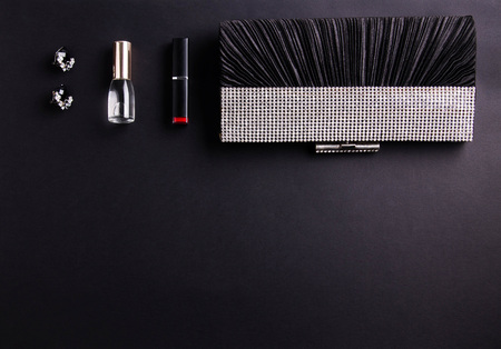 Contents of female handbag including jewellery and cosmetics on black backgroundの写真素材