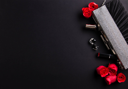 Contents of female handbag including jewellery and cosmetics on black backgroundの写真素材