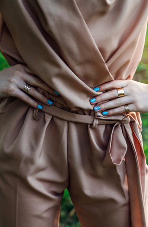 Woman with blue manicure wearing stylish outfit with accessories outsideの写真素材