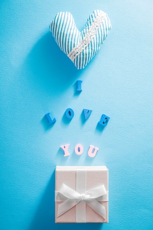 Gift box with I love you lettering and a heart on blue background. Valentine's day concept.の写真素材