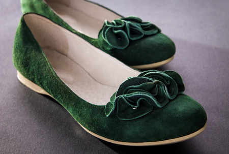 A pair of green suede flats on black backgroundの写真素材