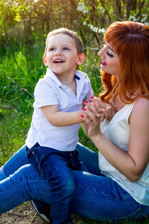 Young mother playing with her little son in spring garden. Mother's Day conceptの写真素材