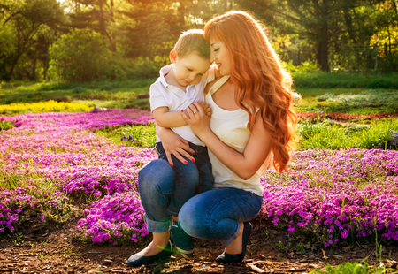 Young mother playing with her little son in spring garden. Mother's Day conceptの写真素材