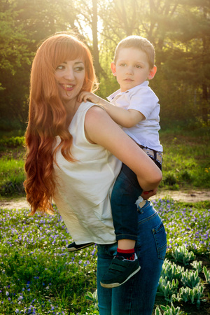Young mother playing with her little son in spring garden. Mother's Day conceptの写真素材