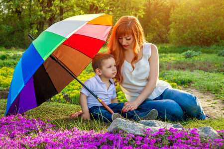 Young mother relaxing with her little son in spring garden. Mother's Day conceptの写真素材