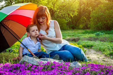 Young mother sitting with her little son in spring garden. Mother's Day conceptの写真素材