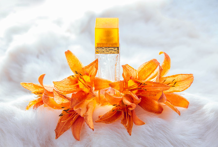 Bottle of perfume with lily on white fur backgroundの写真素材
