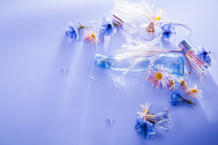 Bottles of perfume with flowers on blue backgroundの写真素材