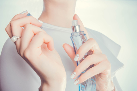 Woman in red dress applying perfume on her wristの写真素材
