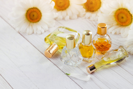 Bottles of perfume with camomile on white backgroundの写真素材