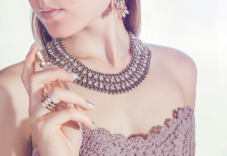 Woman on white background applying perfume on her neckの写真素材