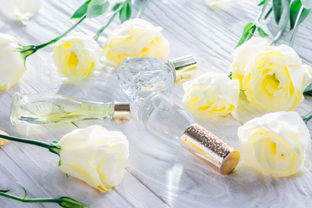 Bottles of perfume with eustoma flowers on white backgroundの写真素材