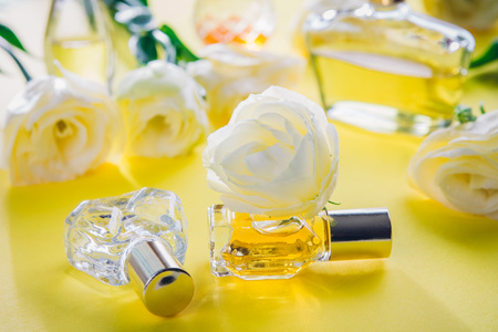 Bottles of perfume with eustoma flowers on yellow backgroundの写真素材