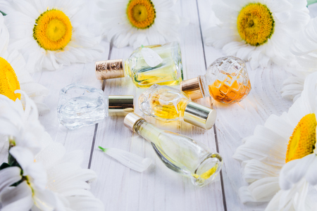 Bottles of perfume with camomile on white backgroundの写真素材