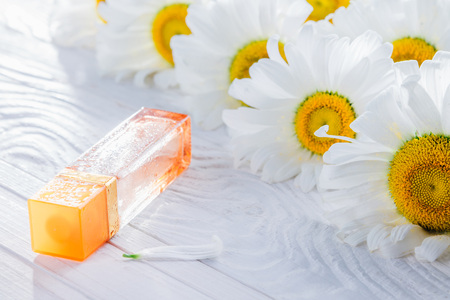 Bottle of perfume with camomile on white backgroundの写真素材