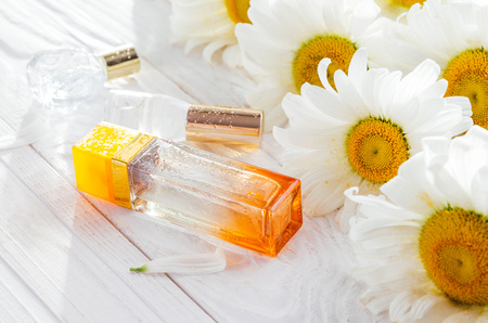 Bottles of perfume with camomile on white backgroundの写真素材