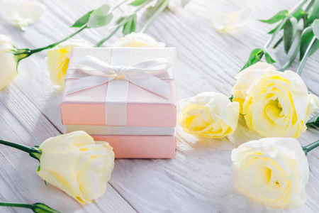 Gift box with flowers on white wooden backgroundの写真素材