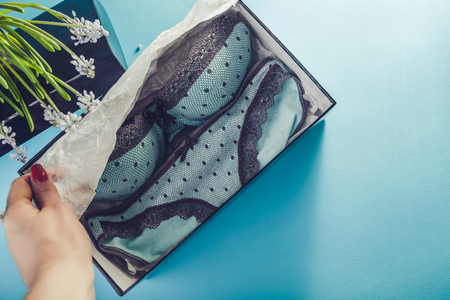 Set of female underwear in the gift box with spring flowers on blue background. A present for a Women's Dayの写真素材