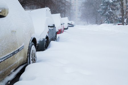 Row of cars covered with snow in the yard. Snowstormの写真素材