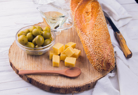 Ingredients for sandwich with cheese, baguette and olives on wooden backgroundの写真素材