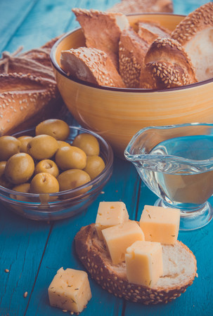 Ingredients for sandwich with cheese, baguette and olives on wooden backgroundの写真素材