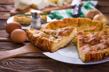 Cabbage pie with onion on wooden tableの写真素材