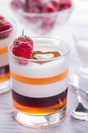 Layered jelly dessert with strawberries on wooden tableの写真素材