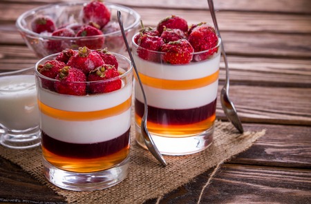 Layered jelly dessert with strawberries on wooden tableの写真素材