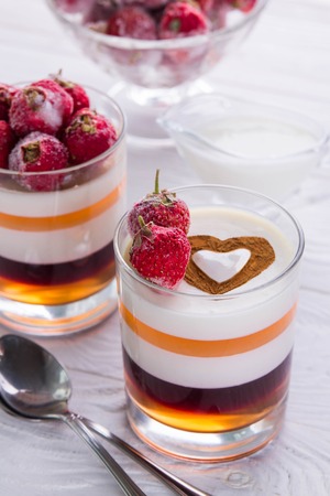 Layered jelly dessert with strawberries on wooden tableの写真素材