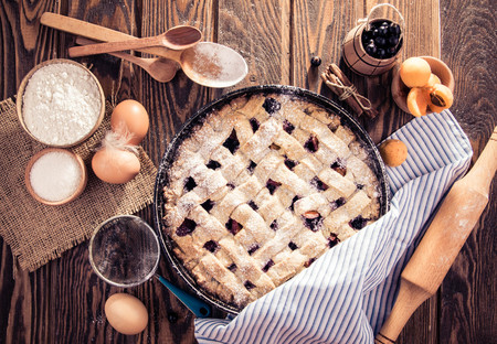 Black currant and apricot pie with ingredients on wooden tableの写真素材