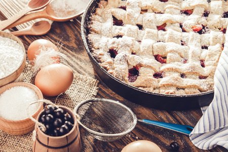 Black currant and apricot pie with ingredients on wooden tableの写真素材