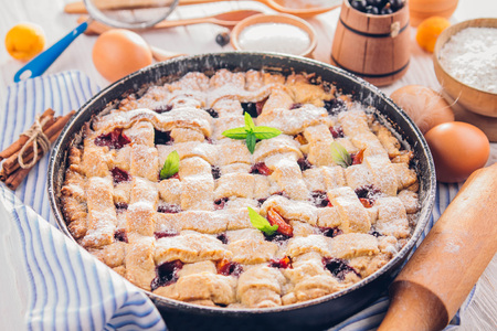 Black currant and apricot pie with ingredients on wooden tableの写真素材