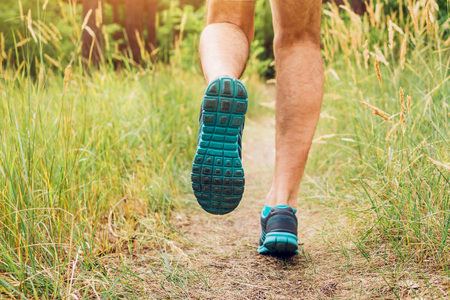 Man running in summer forest at sunsetの写真素材