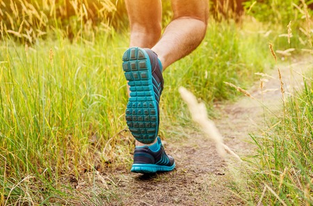 Man running in summer forest at sunsetの写真素材