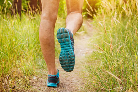 Man running in summer forest at sunsetの写真素材