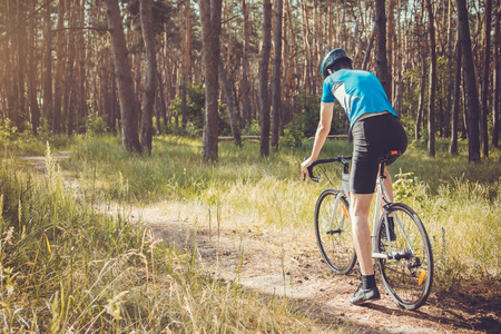 Young bicyclist riding in the forestの写真素材