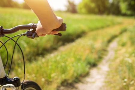 Young bicyclist riding in the field in the morningの写真素材