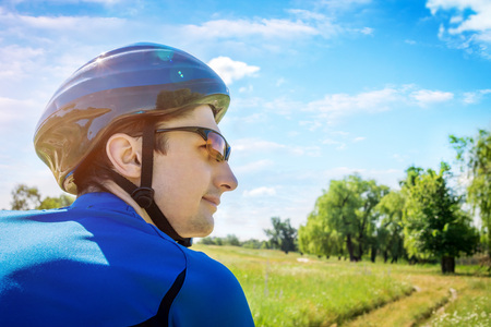 Young bicyclist riding in the field in the morningの写真素材