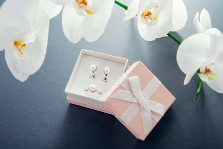 Set of silver ring and earrings with pearls in the gift box with white orchid. Present for a Mothers Dayの写真素材