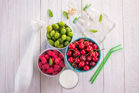 Cooking fruity smoothie with berries using a blenderの写真素材