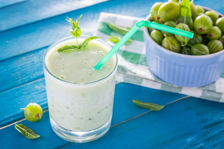 Fruity smoothie with gooseberry on blue tableの写真素材