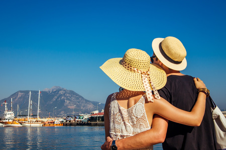 Young couple looks at the Alanya port surrounded by mountainsの写真素材