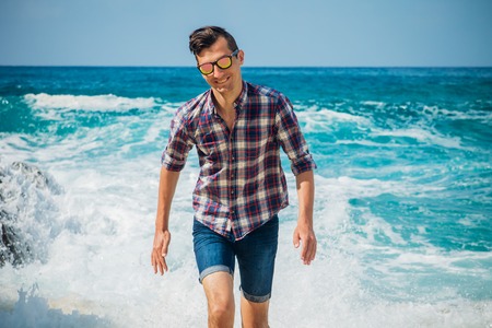 Young man walks on the beachの写真素材