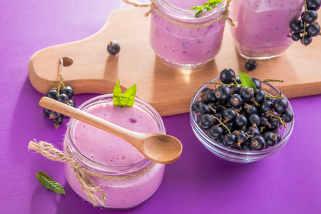 Fruity smoothie in glasses with black currant on purple background. Healthy eating. Organic food.の写真素材